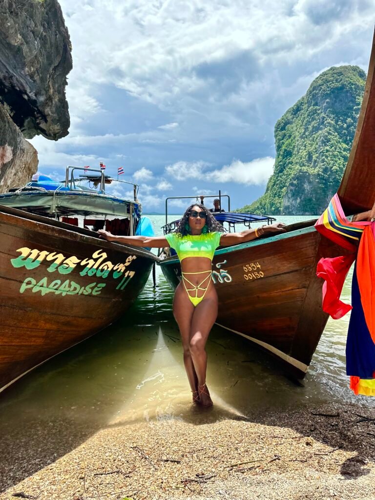 Traveler beside a longtail boat on a tropical beach