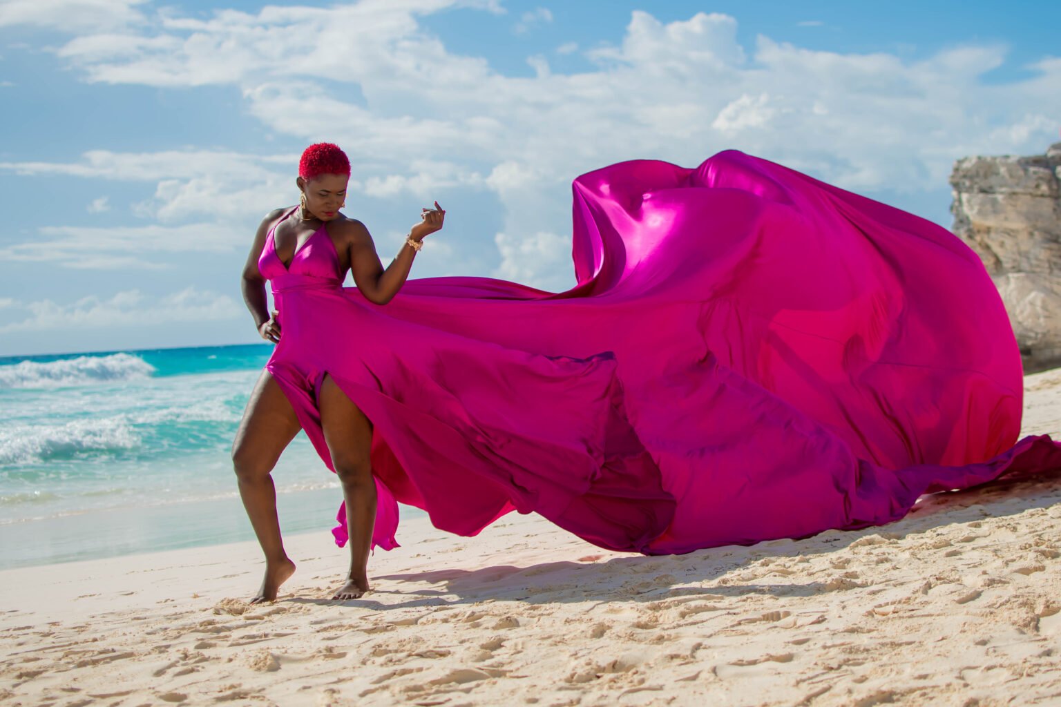 Ndota Travel client in a flowing pink dress on the beach in Cancun