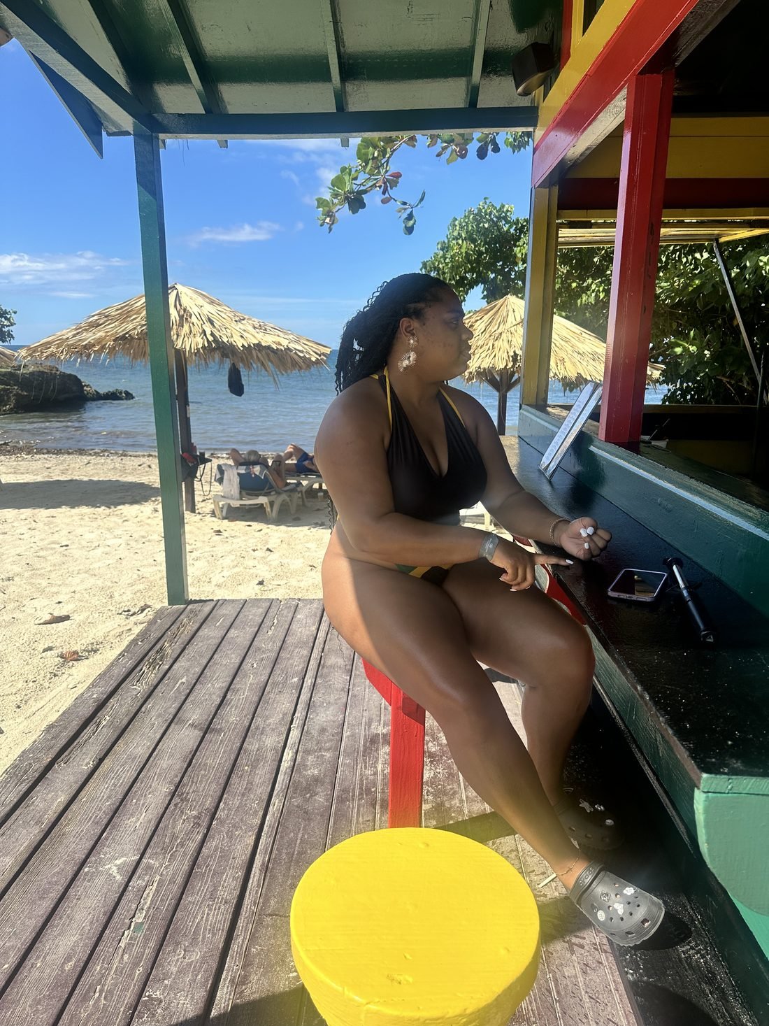Guest at a colourful Jamaican beach bar looking out at the sea